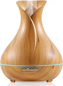 A wood grain LED color-changing diffuser. The diffuser features a sleek, wood-textured exterior with a modern design. It has a soft, ambient light that changes colors, adding a decorative touch to any room. The packaging highlights its ultrasonic misting function and its ability to create a relaxing atmosphere with customizable lighting options